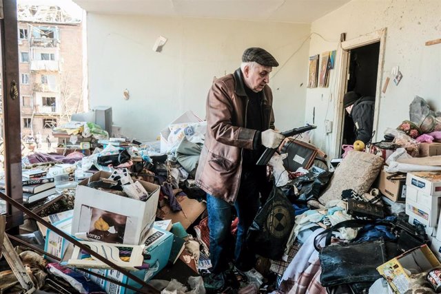 Hombre busca entre los escombros tras un bombardeo ruso en Kiev 