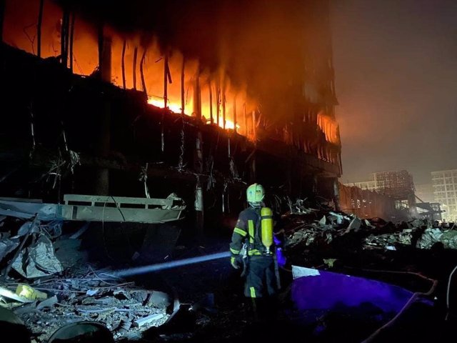 Un bombero observa un centro comercial en llamas en el distrito Podilskyi de Kiev.