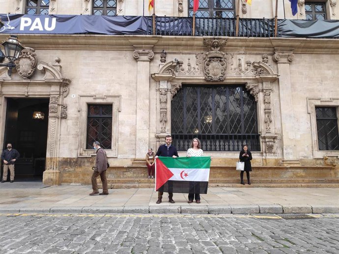 Los ediles de MÉS-Estimam Palma Lloren Carrió y Neus Truyol posan con una bandera saharaui frente al Ayuntamiento de Palma.