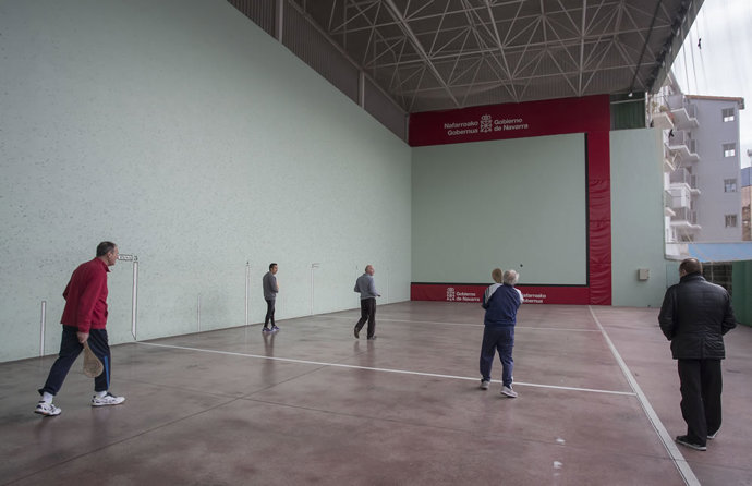 Varias personas juegan en un frontón