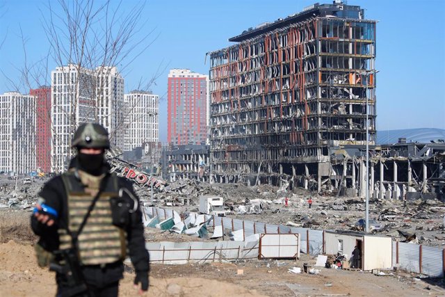 Un policía ucraniano camina sobre una zona comercial debastada por las fuerzas rusas en el distrito de Podilski, Kiev.