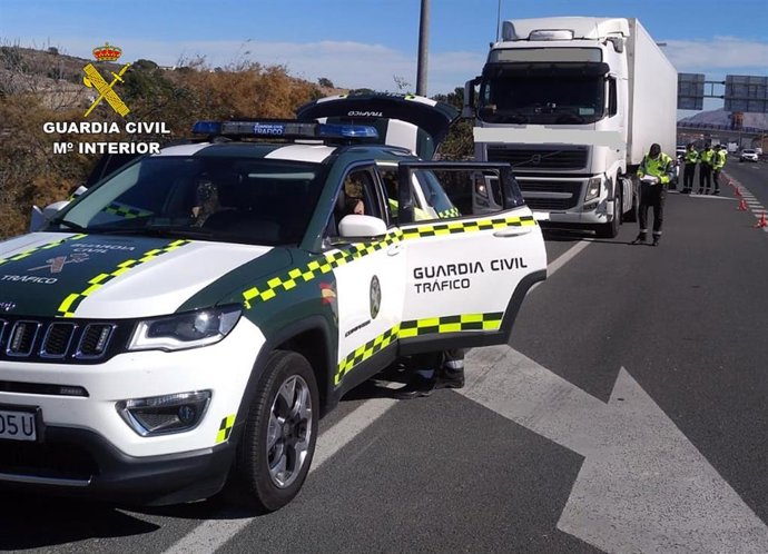 Un vehículo de la Guardia Civil y, detrás, el camión interceptado