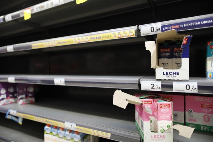 Pocos bricks de leche en la estantería de leche, en un supermercado Carrefour