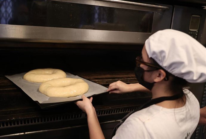Archivo - Una empleada hornea la masa de un roscón