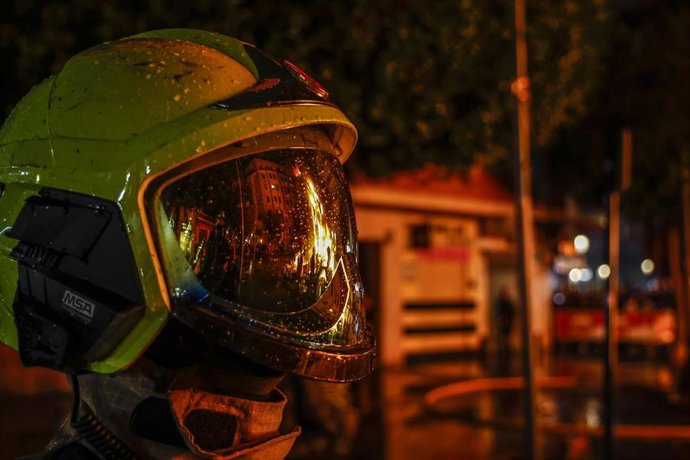 Reflejo de una falla quemándose, en el cristal protector de un casco, durante la Cremá, a 19 de marzo de 2022