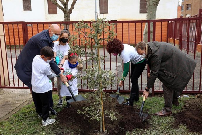 Diez participa en la plantación de  un árbol.
