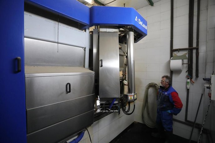 Una operario controla la maquinaria de recogida de leche