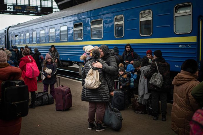 Una mujer y su hija abrazan al padre en la estación de tren de Leópolis después que él llegara de Járkov
