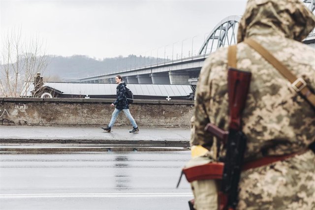 Ucrania asegura que las fuerzas rusas liberarán el lunes a tres periodistas detenidos en Militopol El 2 de marzo de 2022 en Kiev (Ucrania) un civil camina frente a una milicia ucraniana en una calle de Kiev.