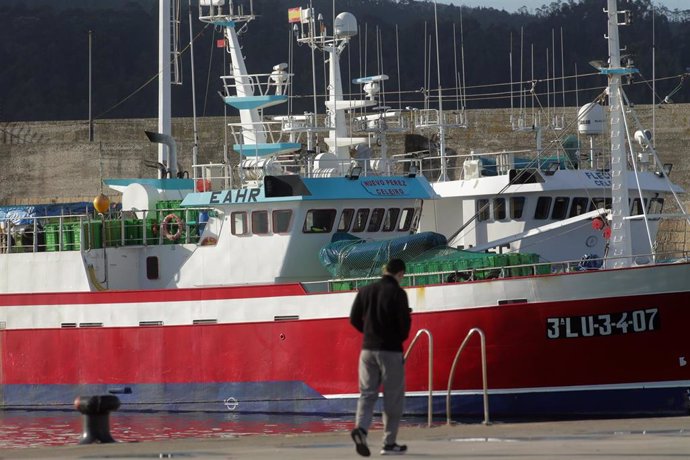 Una persona camina por el puerto de Celeiro, a 8 de marzo de 2022, en Viveiro, Lugo, Galicia (España). La flota de Celeiro, en el municipio lucense de Viveiro, ha iniciado un amarre parcial debido a la subida del precio del gasoil derivada de la guerra 