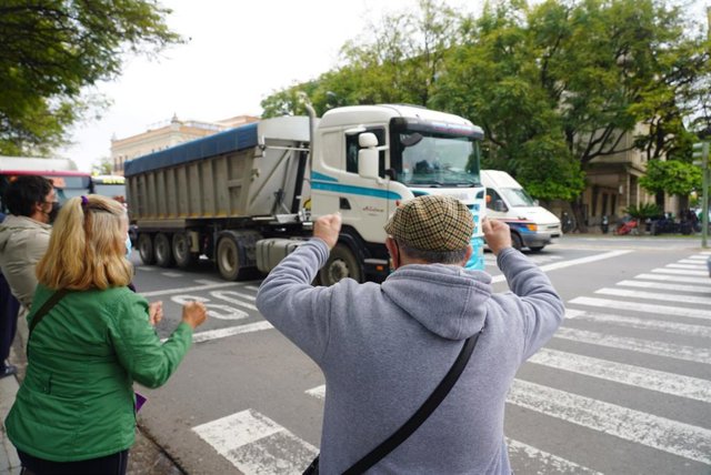 Algunos ciudadanos aplauden al paso de los camiones por la avenida Menéndez Pelayo en señal de apoyo al sector.
