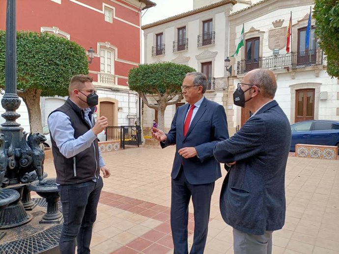 El delegado provincial de Turismo de Almería dialoga con el alcalde y el teniente alcalde de Sorbas frente al ayuntamiento.