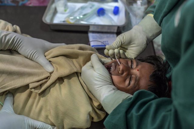 Archivo - Un menor en India se realiza la prueba de diagnóstico de la TB a manos de una miembro de MSF.