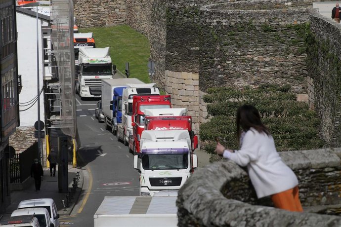 Una mujer observa el paso de los camiones desde el adarve de la Muralla, en una marcha lenta que ha salido desde el polígono de As Gándaras para pasar por varias localizaciones del centro de la ciudad, durante el noveno día de paro nacional de transport