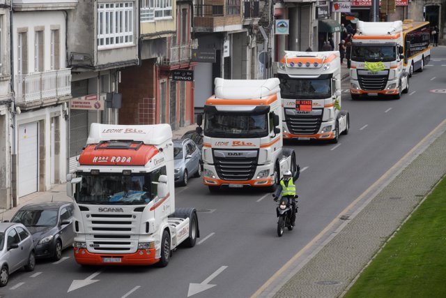 Un motorista apoya a los camiones que pasan por la Ronda de la Muralla, en una marcha lenta que ha salido desde el polígono de As Gándaras, en Lugo, Galicia (España).