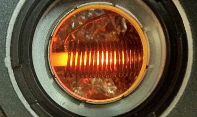 Cristal utilizado para almacenar qubits fotónicos e iluminado por un láser en un criostato, un instrumento para obtener temperaturas criogénicas.