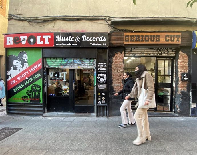 Archivo - Dos personas pasan por delante de la tienda de discos Revolt Music & Records el día de su cierre, a 11 de enero de 2022