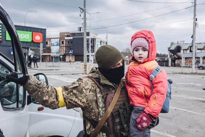 Un soldado ucraniano evacúa a un niño, a 7 de marzo de 2022, en Irpin (Ucrania). El ejército de Ucrania resiste por el momento el duro asedio de Rusia en algunas de sus ciudades, como Irpin y Kiev, donde se recrudecen los combates. Naciones Unidas calcu