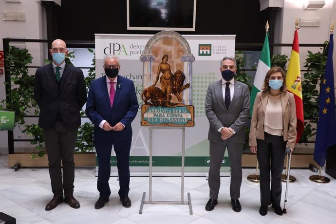 El consejero de la Presidencia, Elías Bendodo, entrega la tercera réplica del escudo de Andalucía al Defensor del Pueblo Andaluz, Jesús Maeztu, junto a la consejera de Empleo, Formación y Trabajo Autónomo, Rocío Blanco, este miércoles en Sevilla