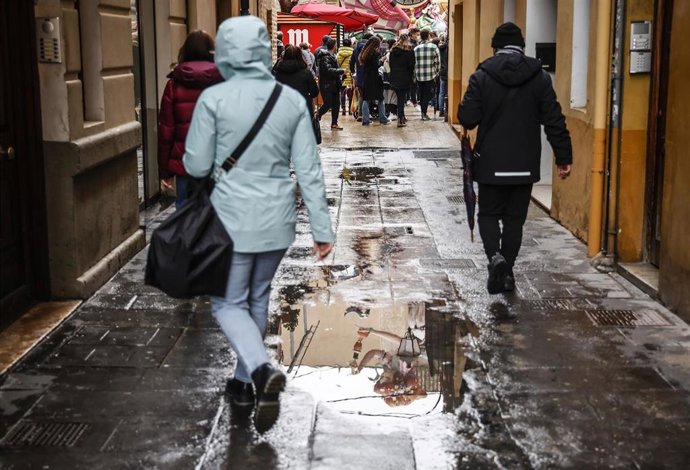 Varias personas pasean un día de lluvia en Valncia 