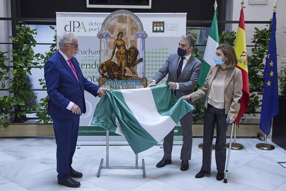 El consejero de Presidencia, Elías Bendodo, (2d) descubre junto a el Defensor del  pueblo andaluz, Jesús Maeztu Gregorio de Tejada, (i) la cerámica durante la entrega al Defensor del Pueblo Andaluz de una réplica del escudo de la Casa de Blas Infante, a