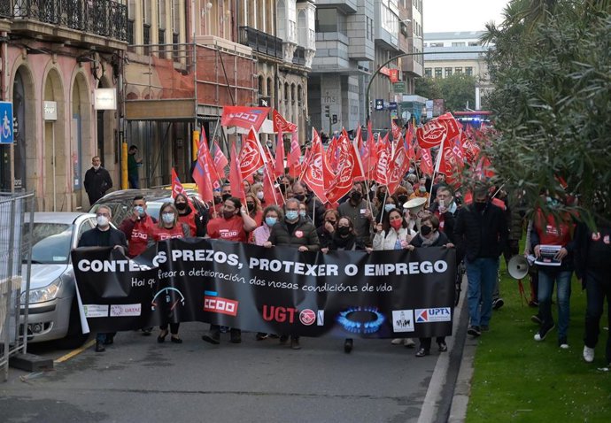 Un grupo de personas sostienen banderines y una pancarta durante una movilización contra los altos precios de la energía eléctrica y en defensa de la protección del empleo en A Coruña