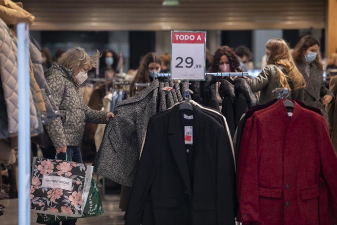 Archivo - Personas en una tienda de ropa