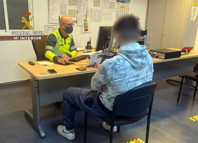 El conductor investigado, frente a un agente de la Guardia Civil