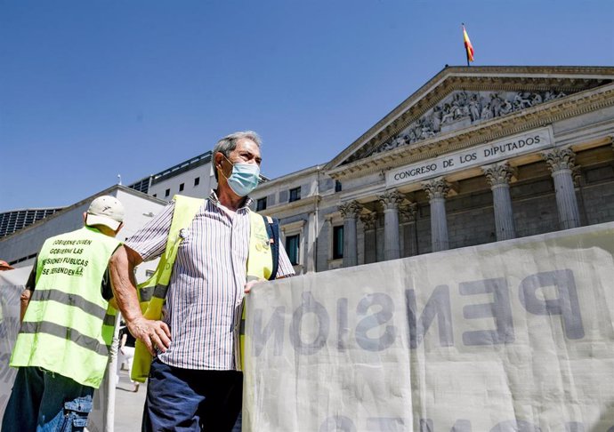 Archivo - Un hombre sostiene una pancarta durante una concentración de protesta frente al Congreso de los Diputados, a 9 de junio de 2021, en Madrid, (España). La concentración, convocada por plataformas de pensionistas de COORPENMADRID-COESPE, tiene co
