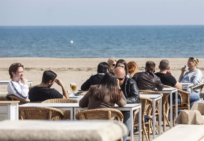 Varias personas en una terraza del Paseo de la Playa de la Malvarrosa, en las Fallas 2022, a 10 de marzo de 2022, en Valencia, Comunidad Valenciana (España). La fiesta valenciana de las Fallas, declarada Patrimonio Inmaterial de la Unesco desde 2016, vu