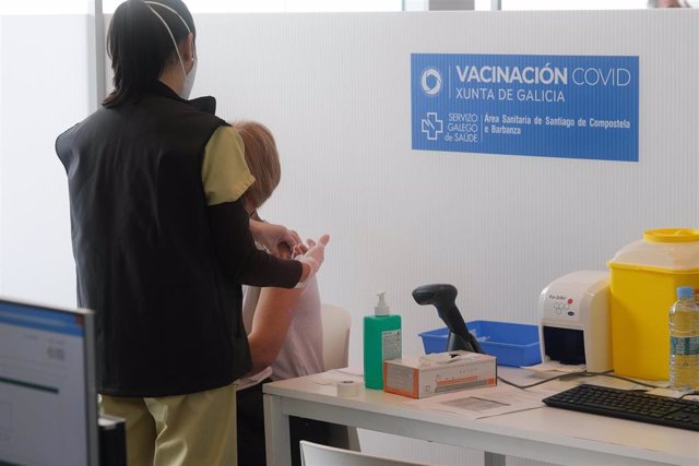 Archivo - Un sanitario vacuna a una persona contra la Covid-19 en Santiago.