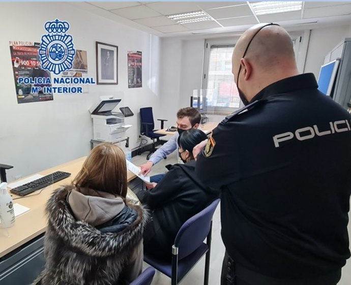 Madre e hija ucranianas asistidas por un intérprete oficial de esa lengua en presencia de un agente de la Policía Nacional en Bilbao