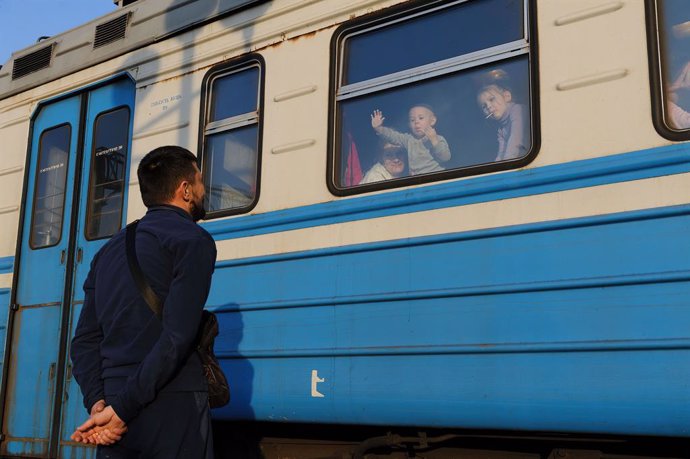 March 15, 2022, Lviv, Ukraine: A man gestures to his family outside a train to Poland at Lviv Railway station amid Russian invasion to Ukraine. Lviv, the largest city in western Ukraine, has now become a transit hub for women and children fleeing to Eur