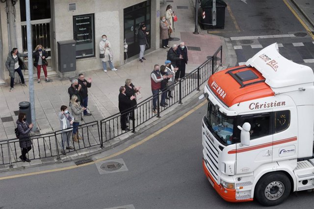 Varias personas aplauden el paso de los camiones por la Ronda de la Muralla, en una marcha lenta que ha salido desde el polígono de As Gándaras para pasar por varias localizaciones del centro de la ciudad, durante el noveno día de paro nacional de transpo