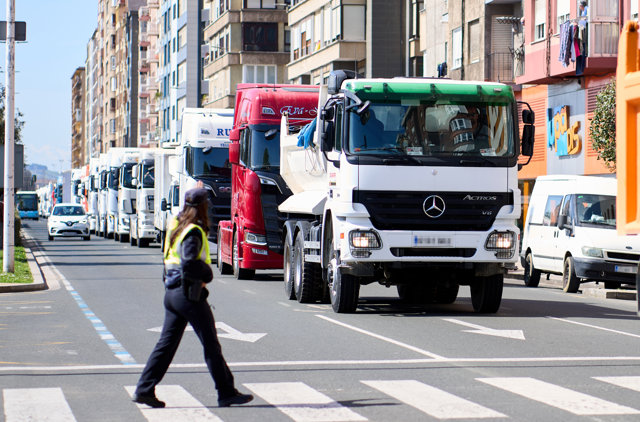 Una agente de Policía Local al lado de una marcha de camiones.