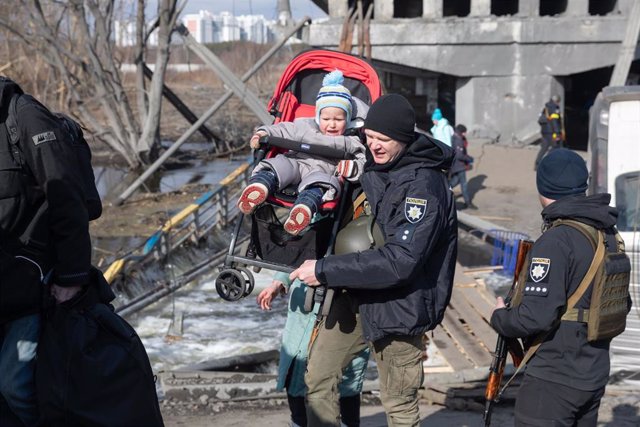 Un militar de Ucrania lleva a un niño durante la evacuación de civiles en la ciudad de Irpin