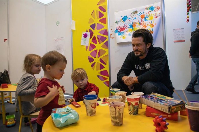Orlando Bloom juega con niños refugiados que huyen de la guerra en Ucrania, en el centro Moldexpo, en Moldavia.