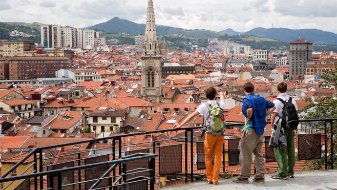 Archivo - Turistas en Bilbao disfrutan de una panorámica de la Villa en la que sobresale a torre de la Catedral de Santiago en del Casco Viejo.