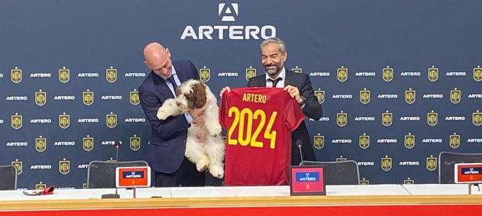 Luis Rubiales sujeta a Musa, la perrita que va a acompañar a la selección española, junto al CEO de Artero, Alex Artero