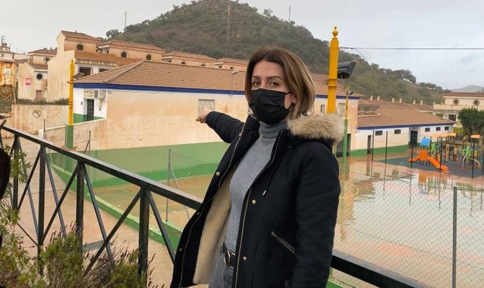 Toñi García, viceportavoz del PSOE en la Diputación, señala cómo ha quedado una fachada en Almogía (Málaga) tras las lluvias con barro de estos días