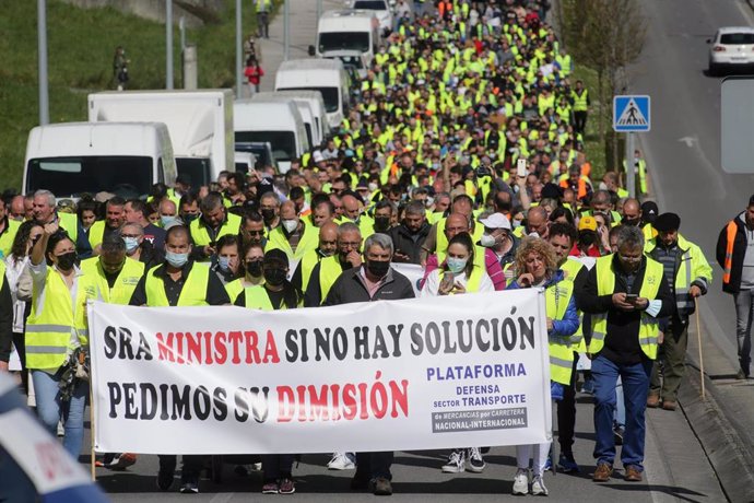 Varias personas con una pancarta en la que piden la dimisión de la ministra de Tranportes, en una marcha en la que han participado 400 camioneros, durante el undécimo día de paro nacional de transportistas, a 24 de marzo de 2022, en Lugo