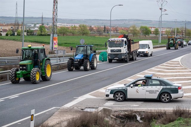 Un vehículo de la Guardia Civil vigila a los tractores circulan como protesta por la carretera M-404, desde Titulcia a Torrejón de la Calzada