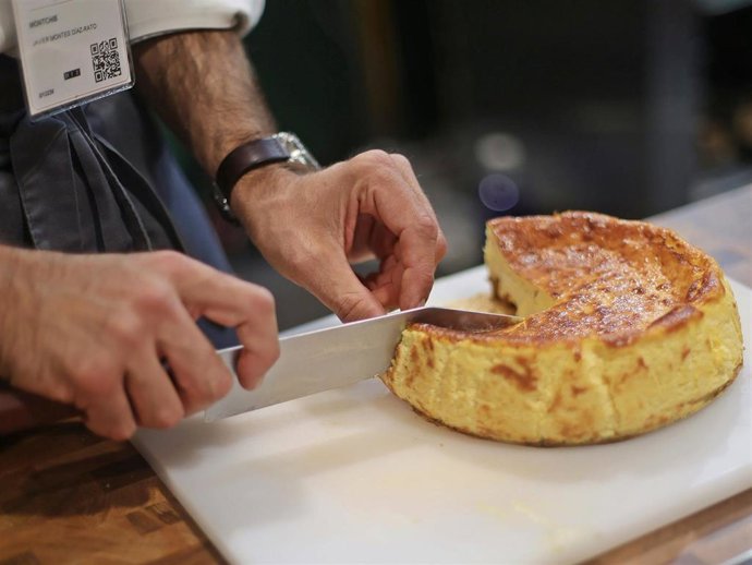 Un camarero corta una porción de tarta de queso en un stand durante el día de apertura de Madrid Fusión 2021 en Feria de Madrid IFEMA, a 31 de mayo de 2021, en Madrid (España).