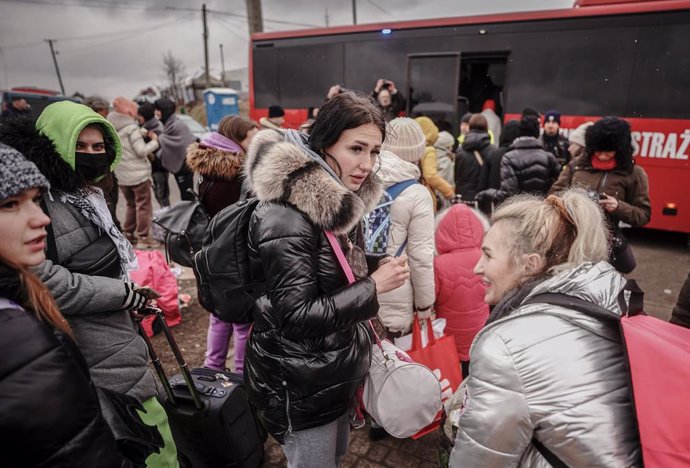 05 March 2022, Poland, Medyka: Refugees from Ukraine wait for the bus at the Ukrainian-Polish border in Medyka, to continue their journey into Poland. More than a milion people have fled Ukraine to the neighbouring countries due to the Russian invasion.