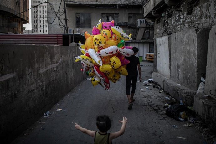 Archivo - Niño persigue globos en Bagdad