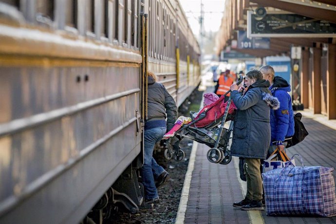 23 March 2022, Poland, Przemysl: A Ukrainian refugee woman unloads her daughter in a kids chair after arriving to Przemysl from Lviv by train escaping of the war after the invasion of Ukraine by Russia. Photo: Celestino Arce Lavin/ZUMA Press Wire/dpa