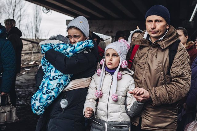 Varias personas con niños esperan para cruzar el río de Irpin, a 5 de marzo de 2022, en Irpin (Ucrania)