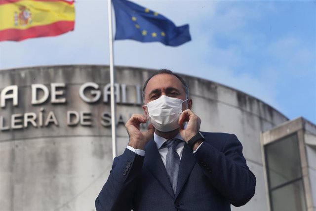 Archivo - El conselleiro de Sanidade, Julio García Comesaña, se coloca la mascarilla para posar en una entrevista con Europa Press.