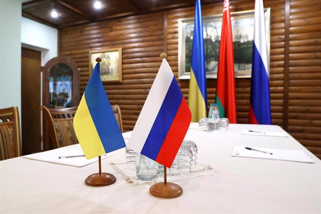 Banderas de Ucrania y Rusia en una mesa para la negociación en Bielorrusia