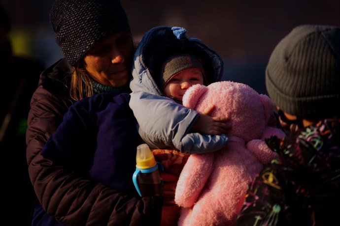 19 March 2022, Poland, Kroscienko: A young child from Ukraine holds a large teddy bear after her family crossed a border point into Poland's Kroscienko. Photo: Victoria Jones/PA Wire/dpa